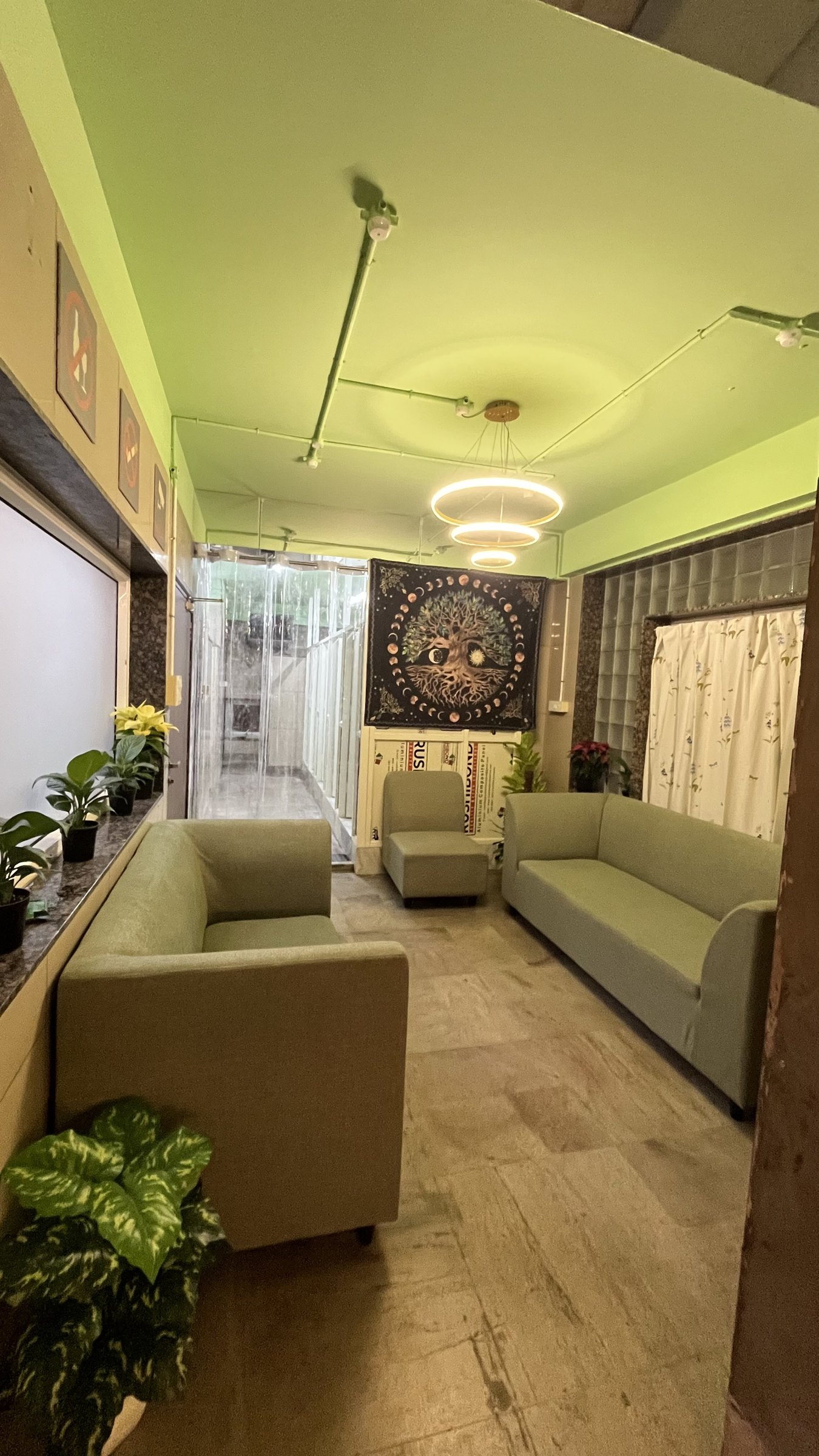 A warm Nia Studio lounge with sofas under a chandelier